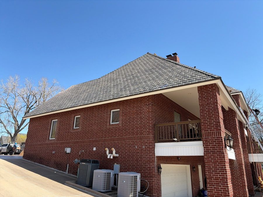 Finished tile roof on a brick home with McRay Roofing truck on site