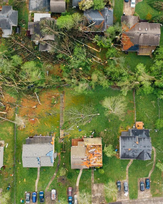 Aerial view of a neighbourhood with tarped, storm-damaged roofs